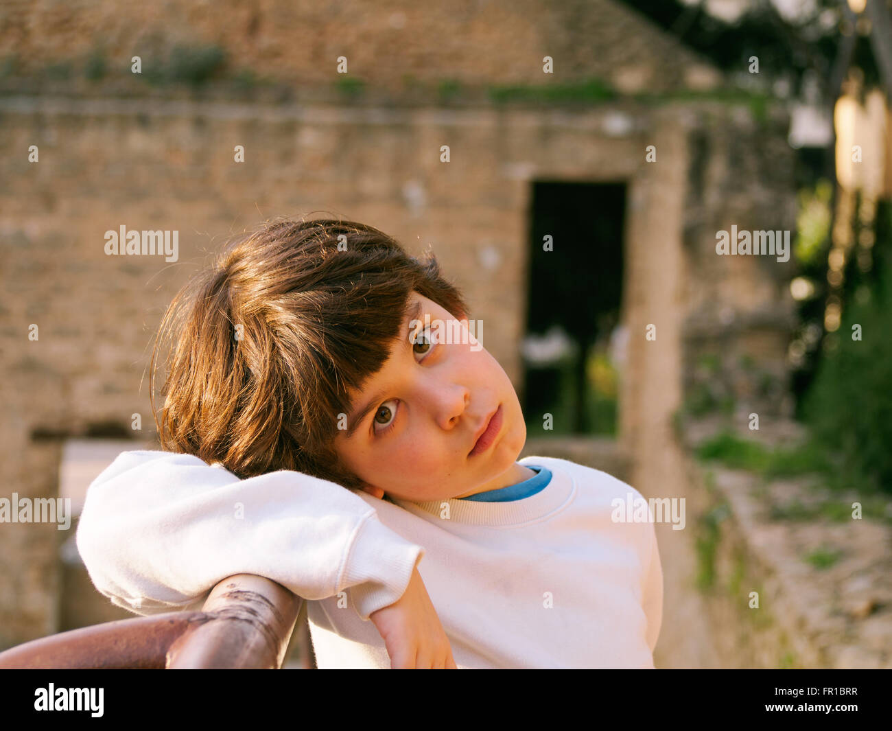 Giovane età elementare ragazzo giocando all'aperto ion un parco giochi Foto Stock