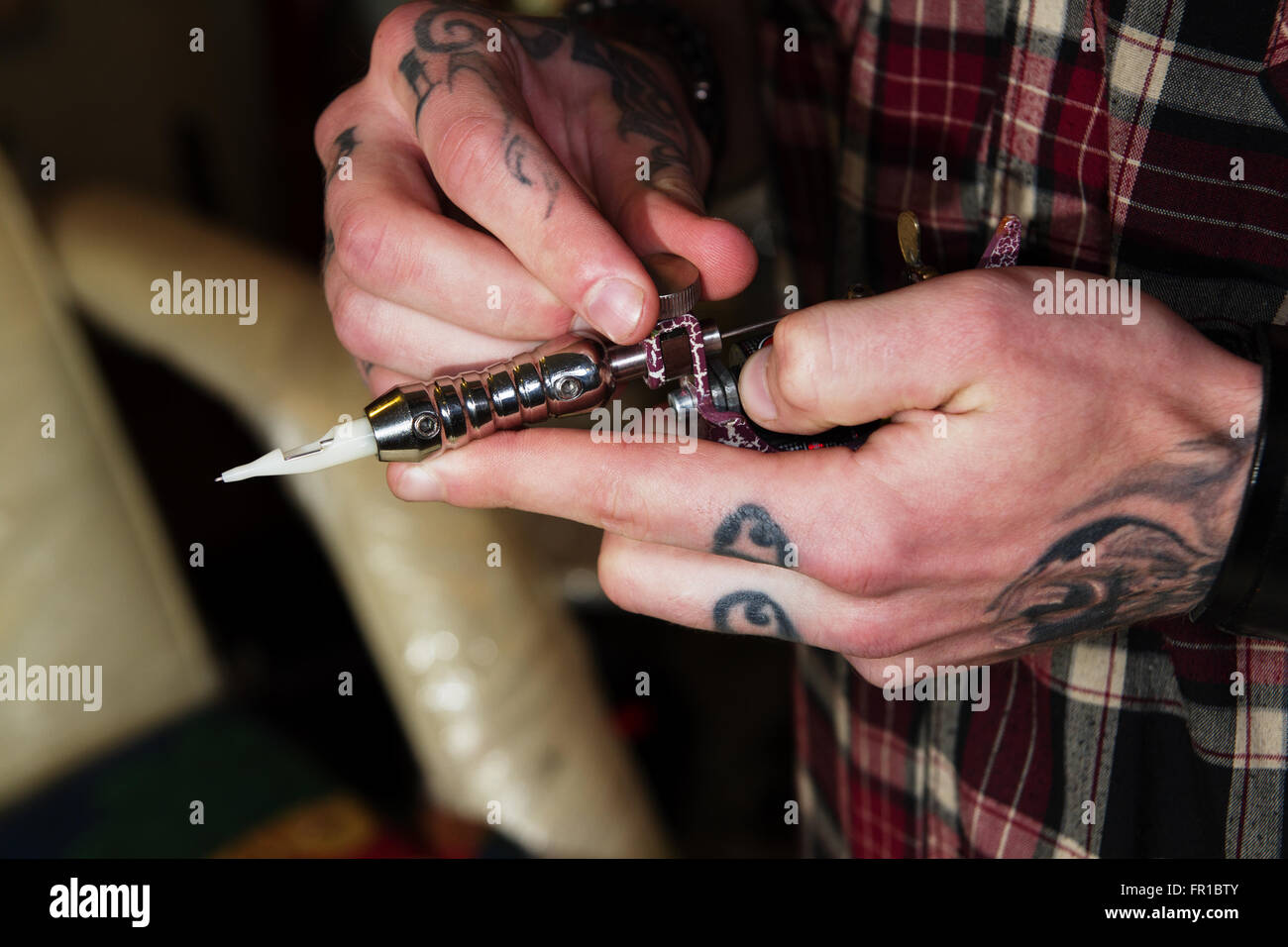 Macchina professionale per la realizzazione di un tatuaggio in pesanti tatuato le mani di un maestro Foto Stock
