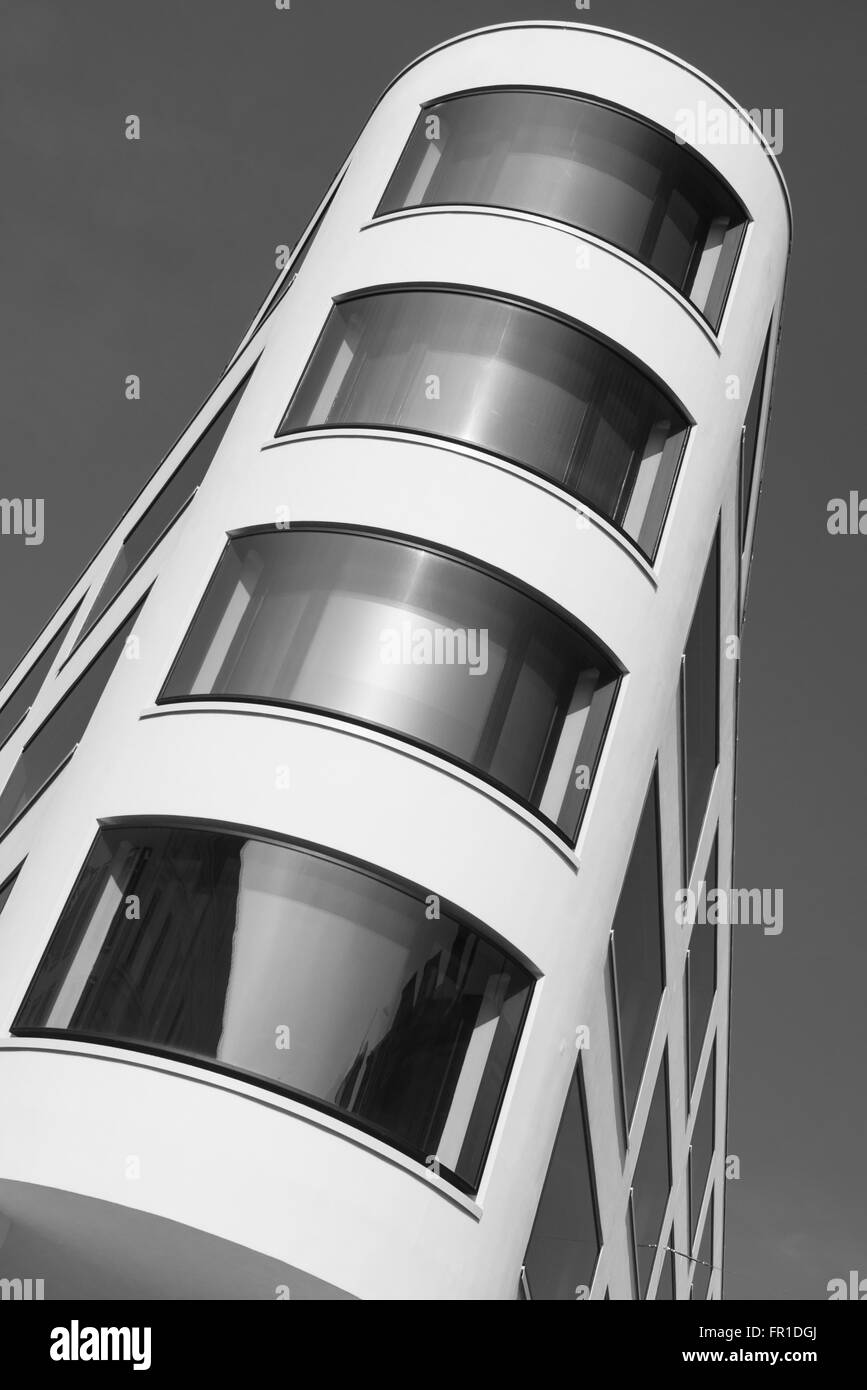 Architettura moderna e la facciata ricurva con finestre di vetro in un edificio's corner a Monaco di Baviera, Germania Foto Stock