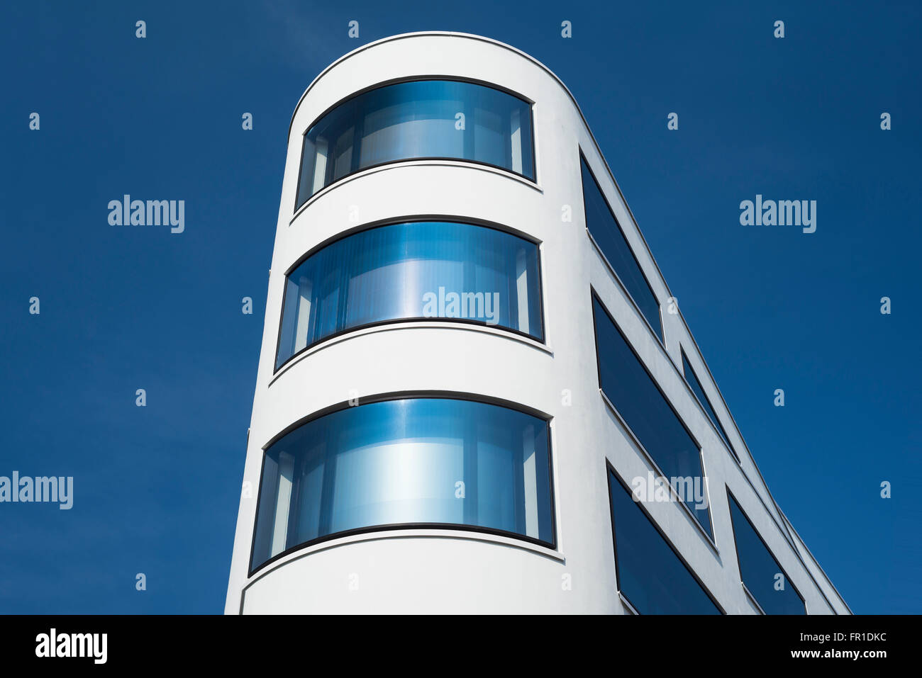 Architettura moderna e la facciata ricurva con finestre di vetro in un edificio's corner a Monaco di Baviera, Germania Foto Stock