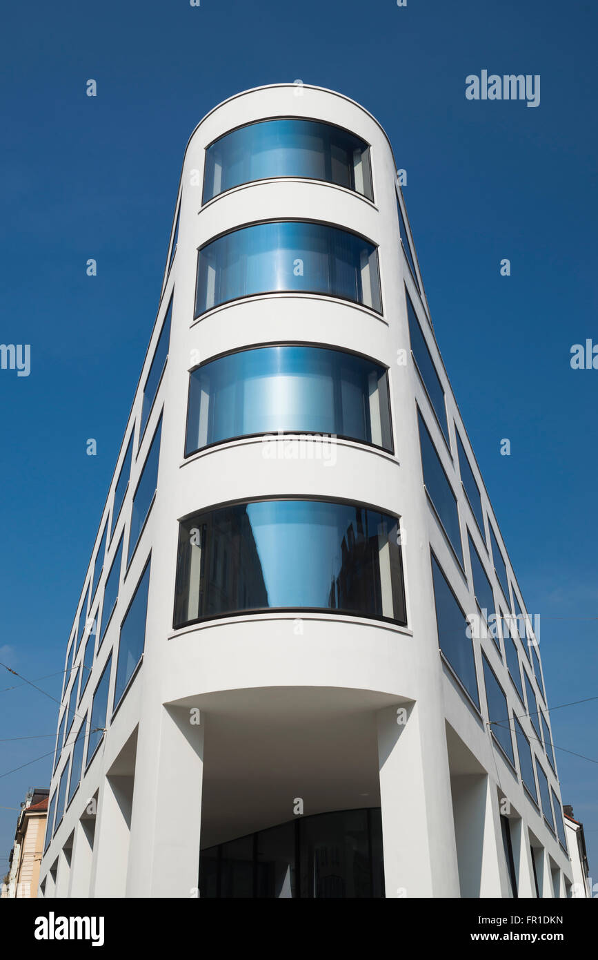 Architettura moderna e la facciata ricurva con finestre di vetro in un edificio's corner a Monaco di Baviera, Germania Foto Stock