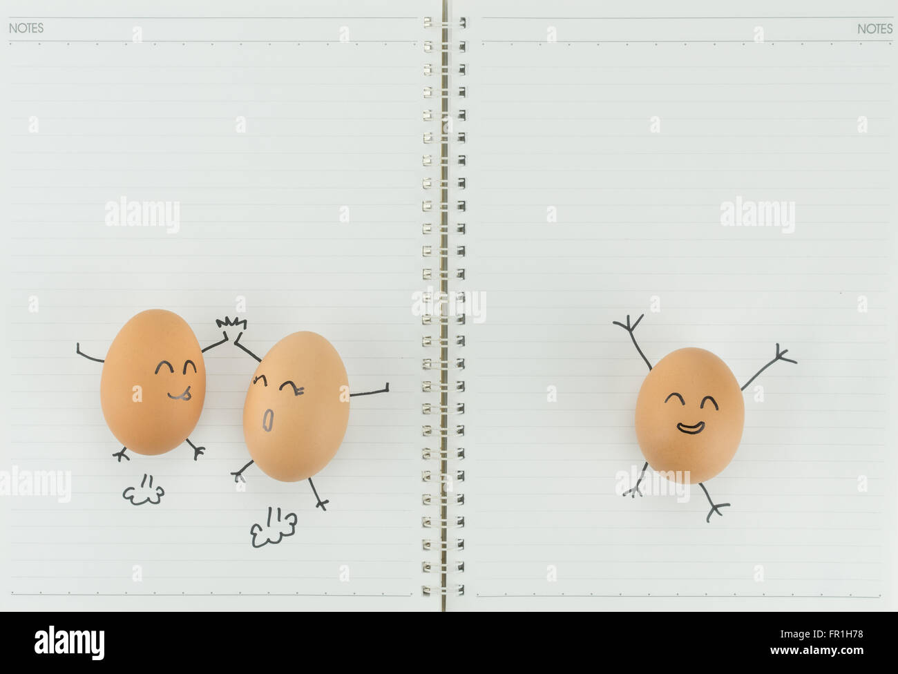Tre uova felice con copia spazio vuoto su carta per notebook Foto Stock