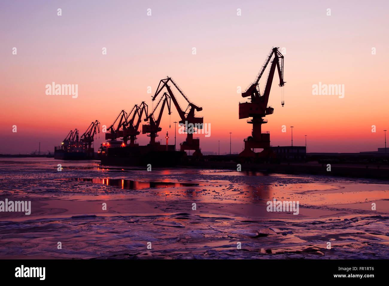 In serata la silhouette di Gru portuali Foto Stock