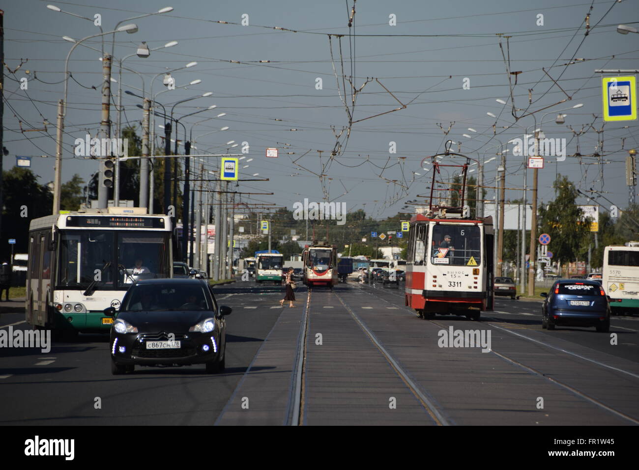 I tram e gli autobus nel traffico misto a Nalichnaya Street a San Pietroburgo Foto Stock