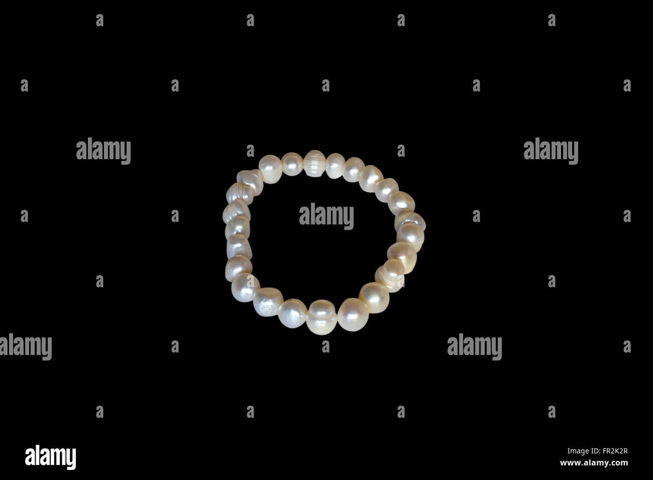 Bracciale di mare bianco perle su uno sfondo nero Foto Stock