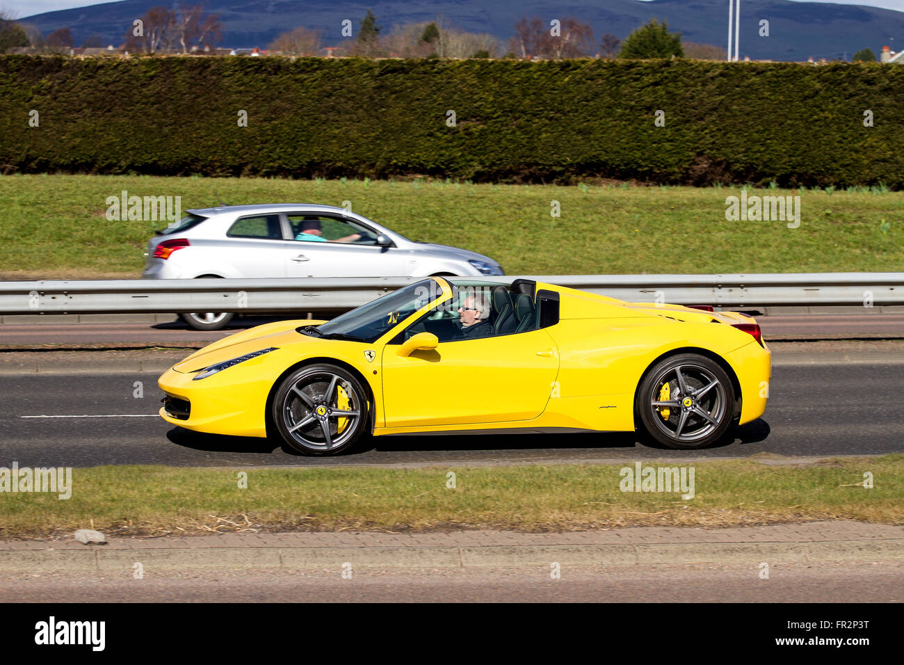 Un giallo Ferrari 458 Italia convertibile spider auto sportiva che viaggia lungo il Kingsway West a doppia carreggiata a Dundee, Regno Unito Foto Stock