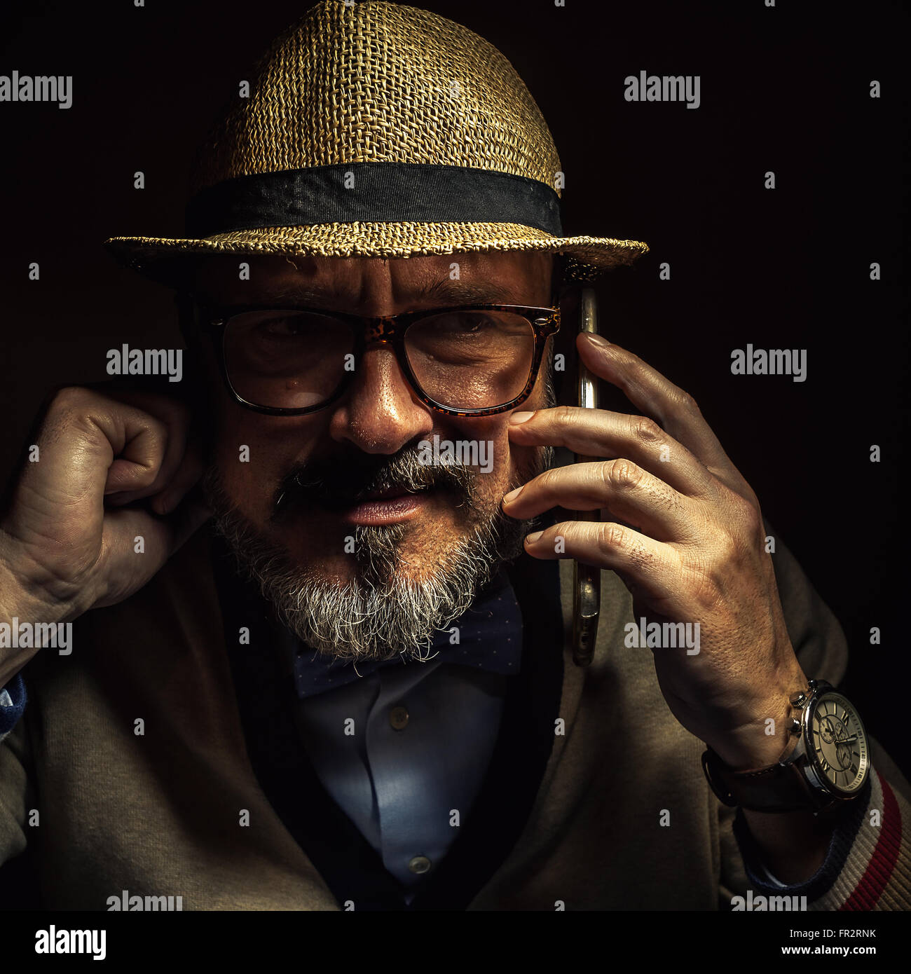 Le persone più anziane di comunicare tramite telefono cellulare, indossando uno stile rétro vestiti, occhiali e cappello. Foto Stock
