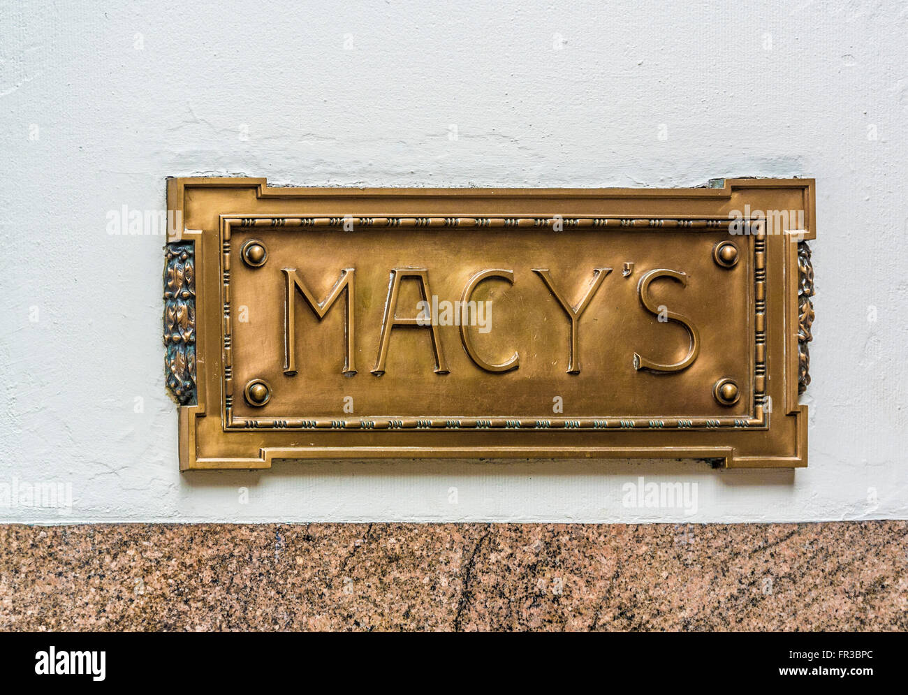 Macy's segno in ottone sulla parete del department store di New York City, Stati Uniti d'America. Foto Stock