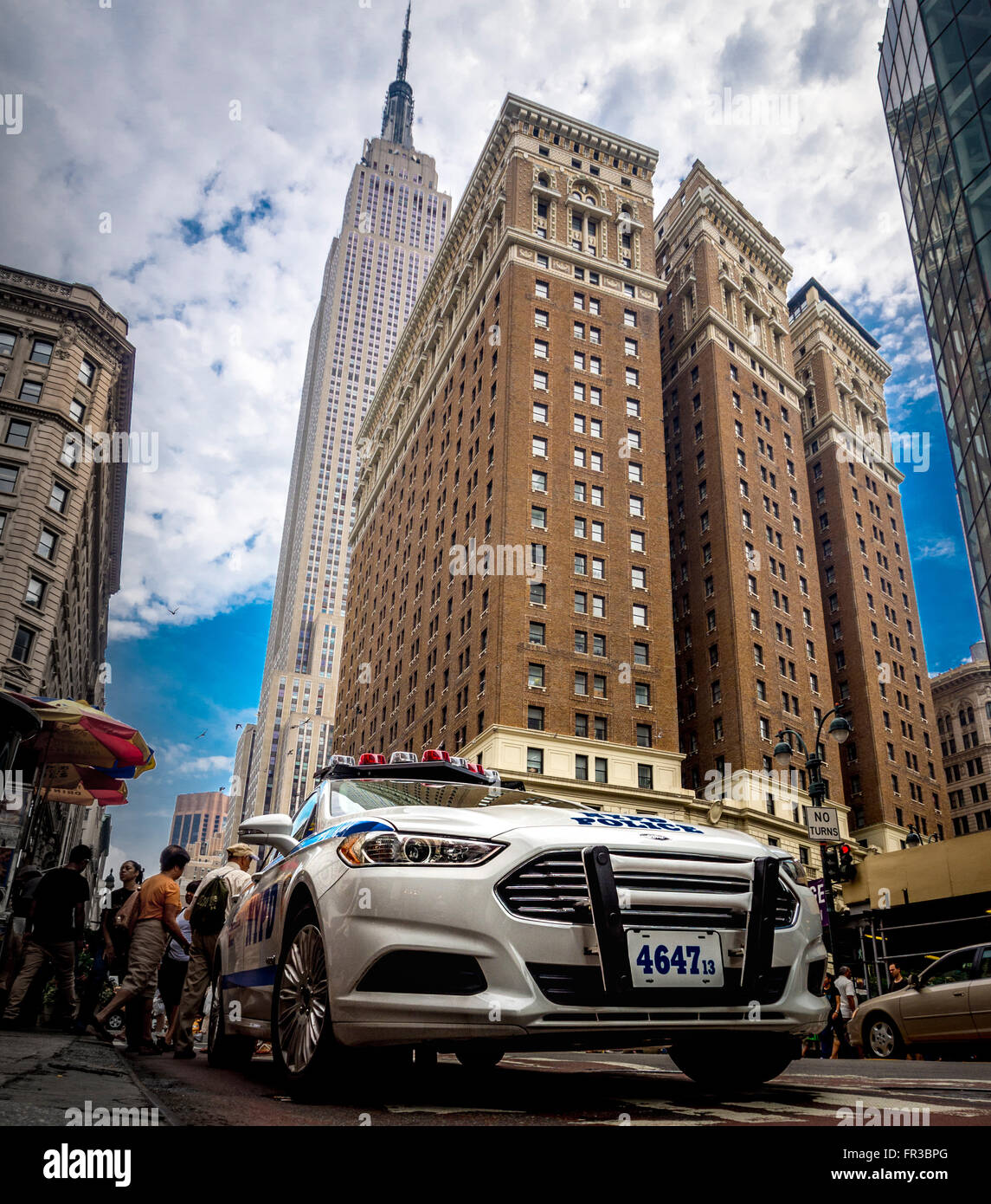 NYPD auto di pattuglia con Empire State Building visto da W 34th St, New York City, Stati Uniti d'America. Foto Stock