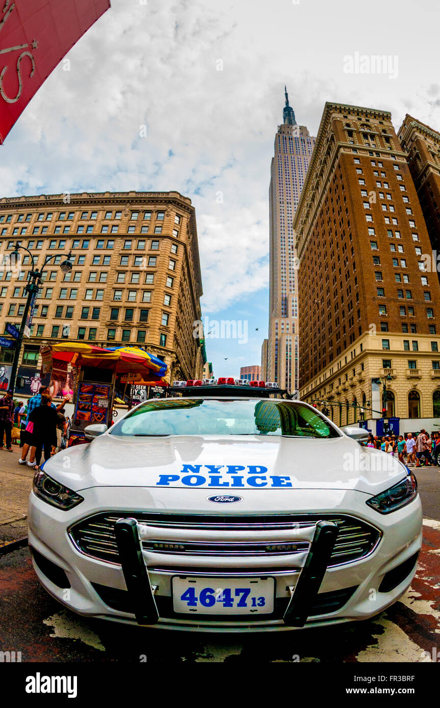 NYPD auto di pattuglia con Empire State Building visto da W 34th St, New York City, Stati Uniti d'America. Foto Stock