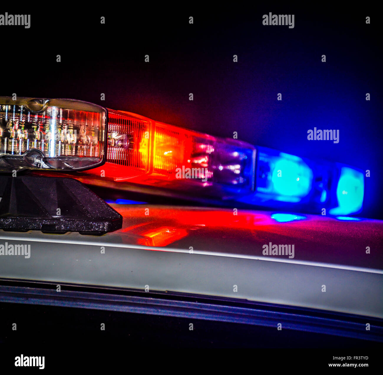 Rosso e blu polizia lampeggiante luci auto sulla cima di una pattuglia di notte durante la conduzione di applicazione della legge business Foto Stock