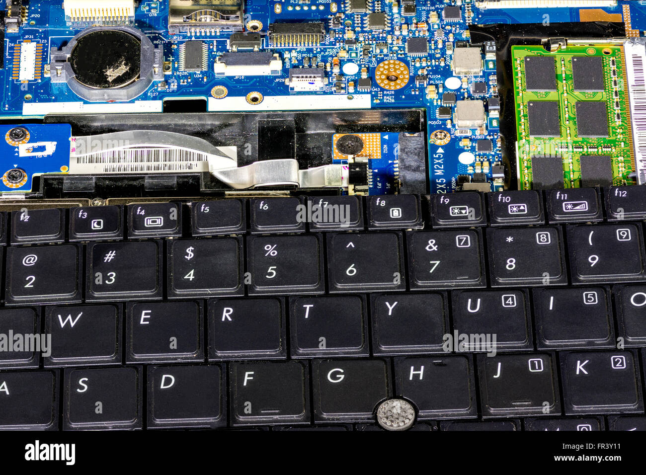 Rotto vecchio portatile con la tastiera e la scheda di circuito esposta Foto Stock