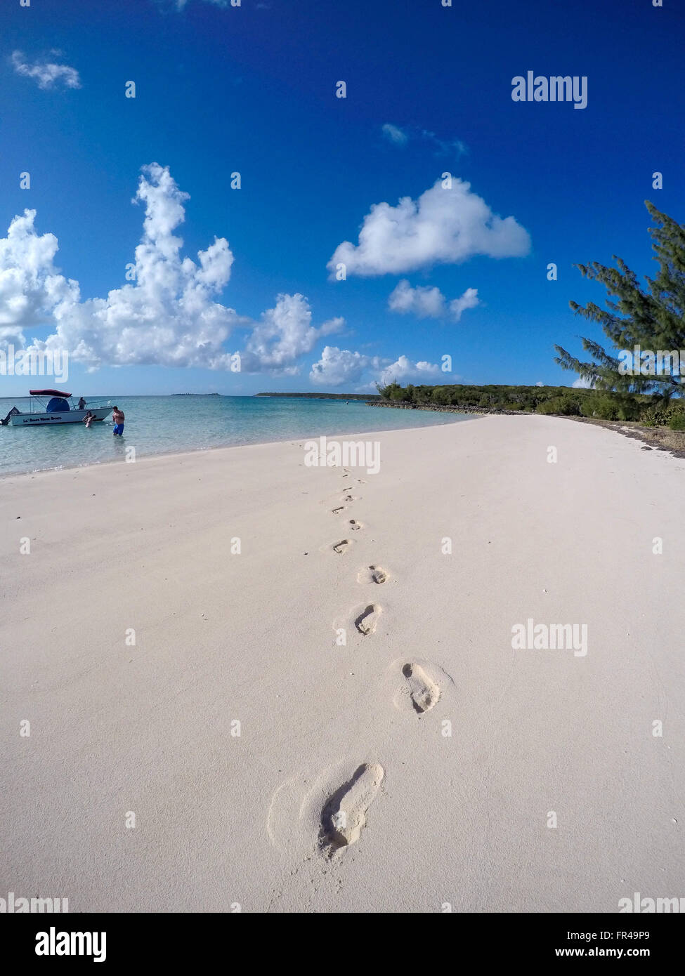 Natura: impronte nella sabbia con un uomo e una barca in background. Foto Stock