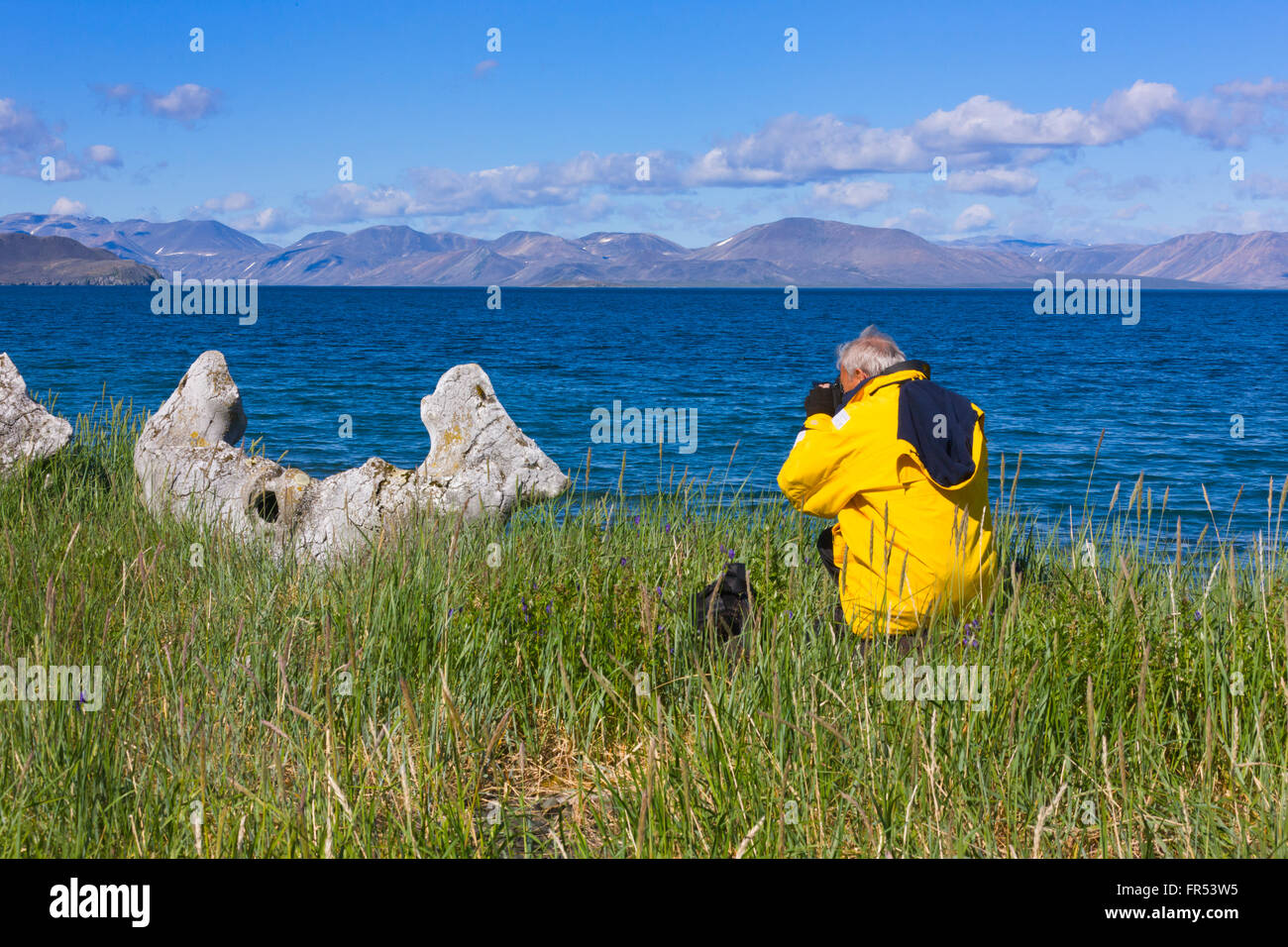 I turisti fotografare Bowhead Whale ossa mandibolari, Yttygran Isola del Mare di Bering, Estremo Oriente Russo Foto Stock