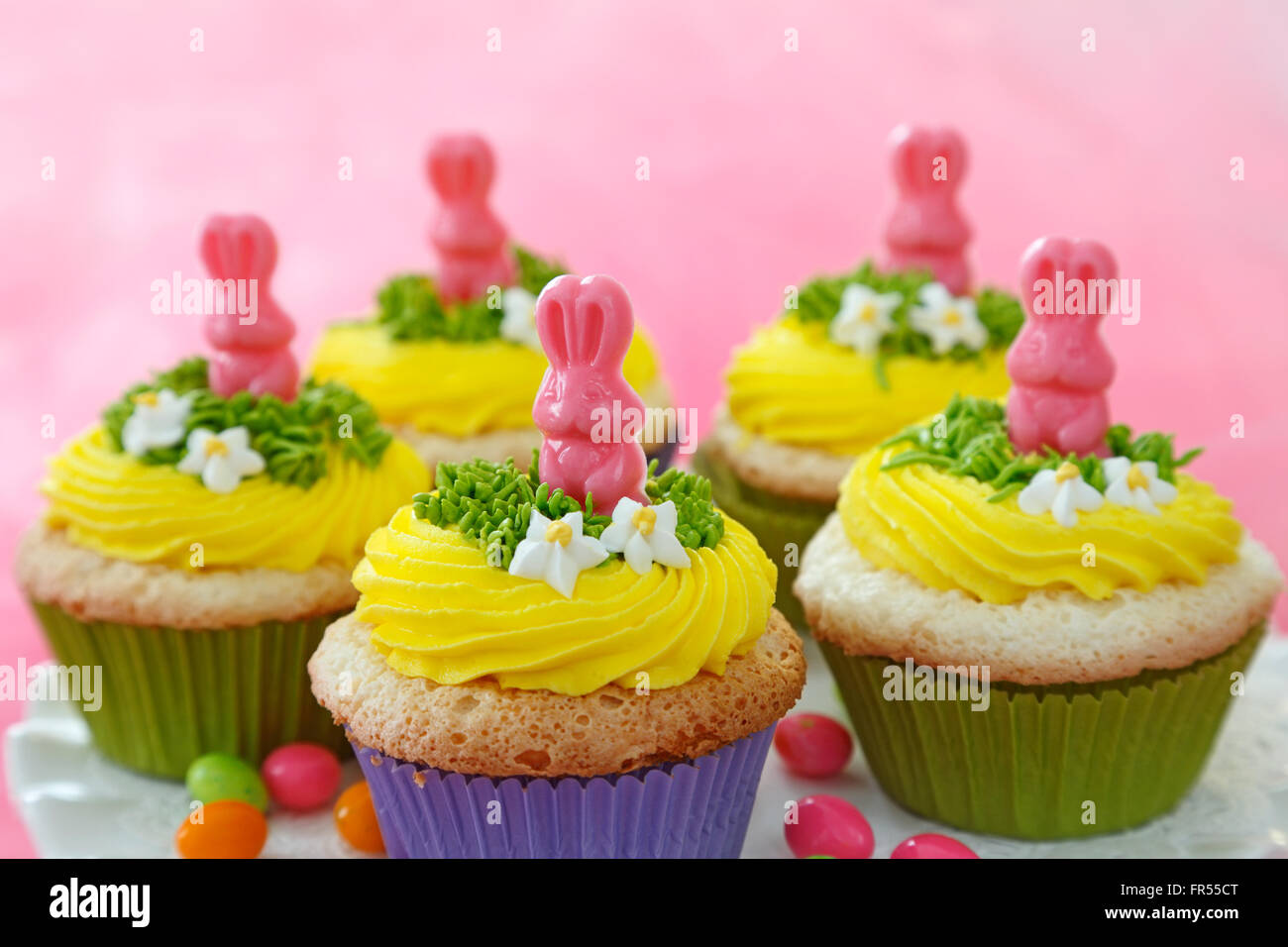 Tortini di Pasqua decorate con conigli di cioccolato e crema di burro giallo. Foto Stock