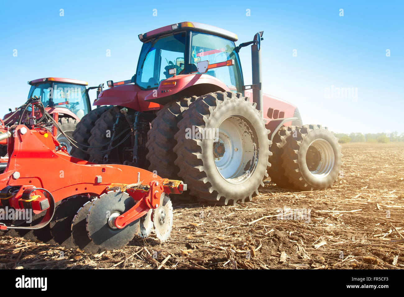 Due trattori in un campo su un luminoso giorno di sole Foto Stock