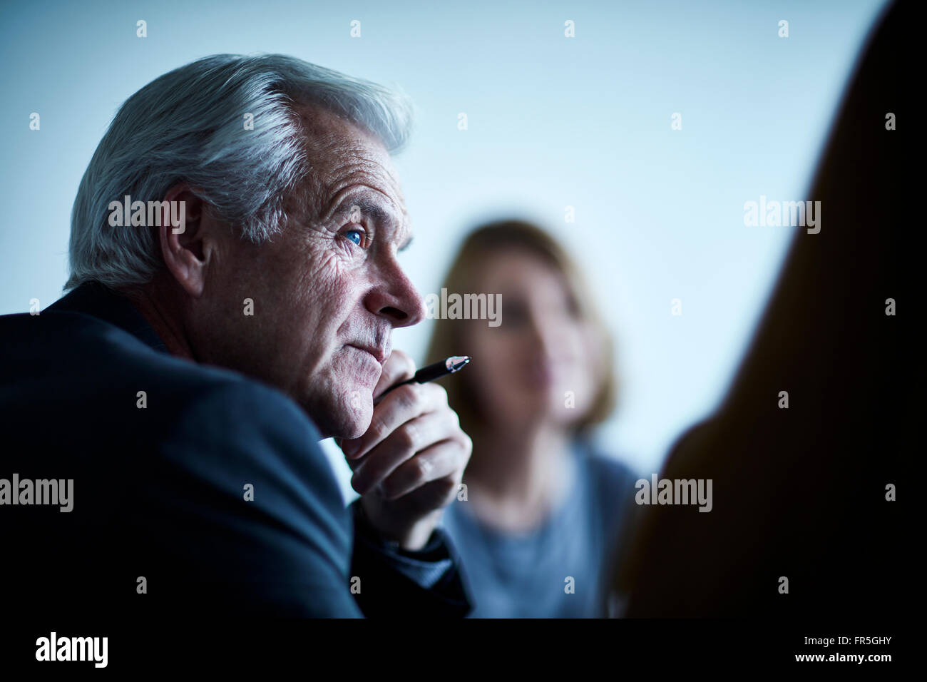 Attento businessman senior di ascolto in riunione Foto Stock