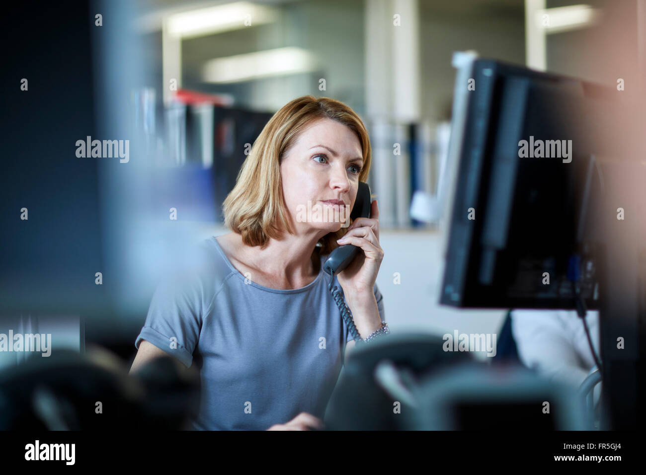 Imprenditrice parlando al telefono e lavorare al computer Foto Stock