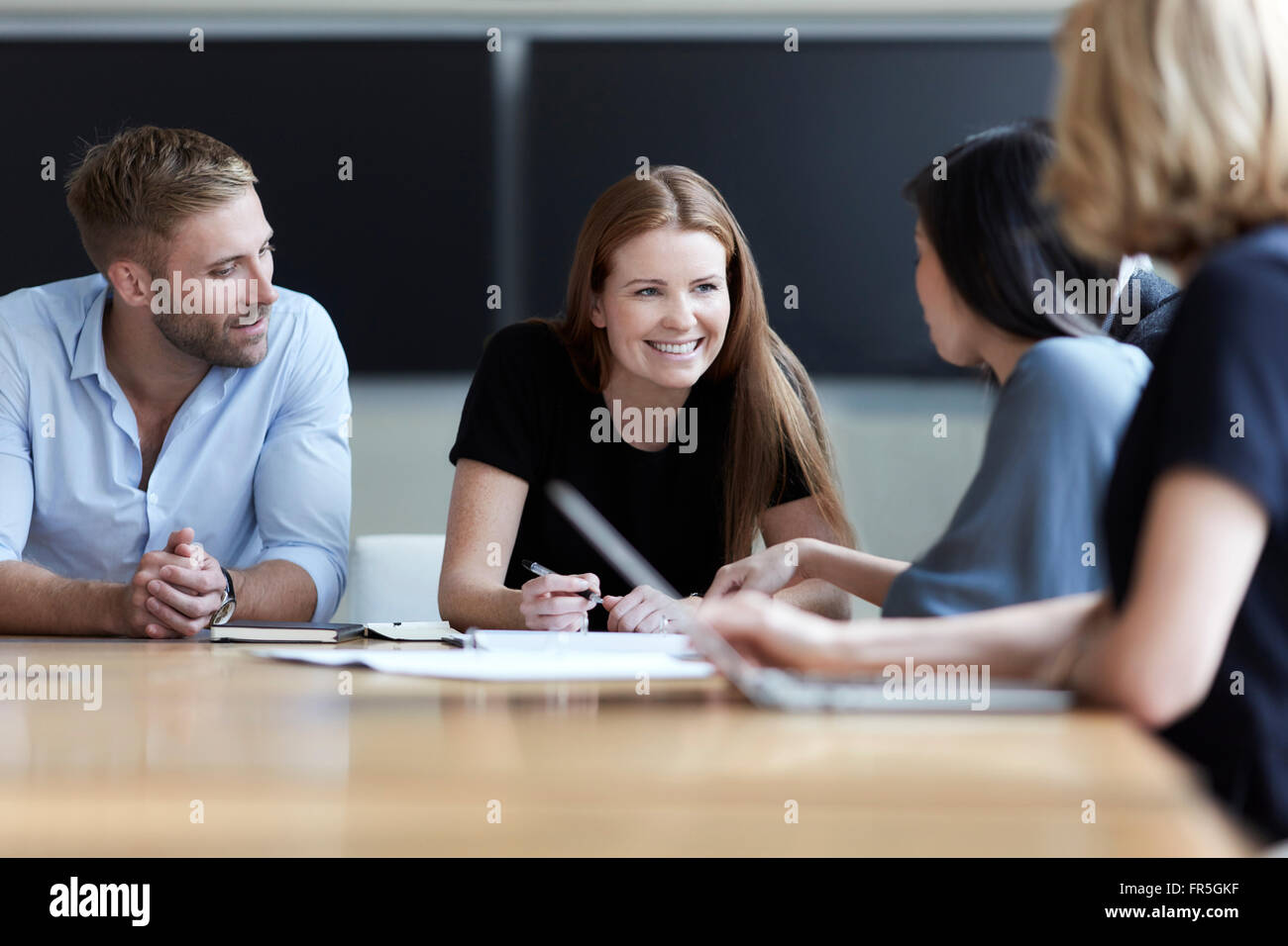 Sorridente business persone che parlano in riunione Foto Stock