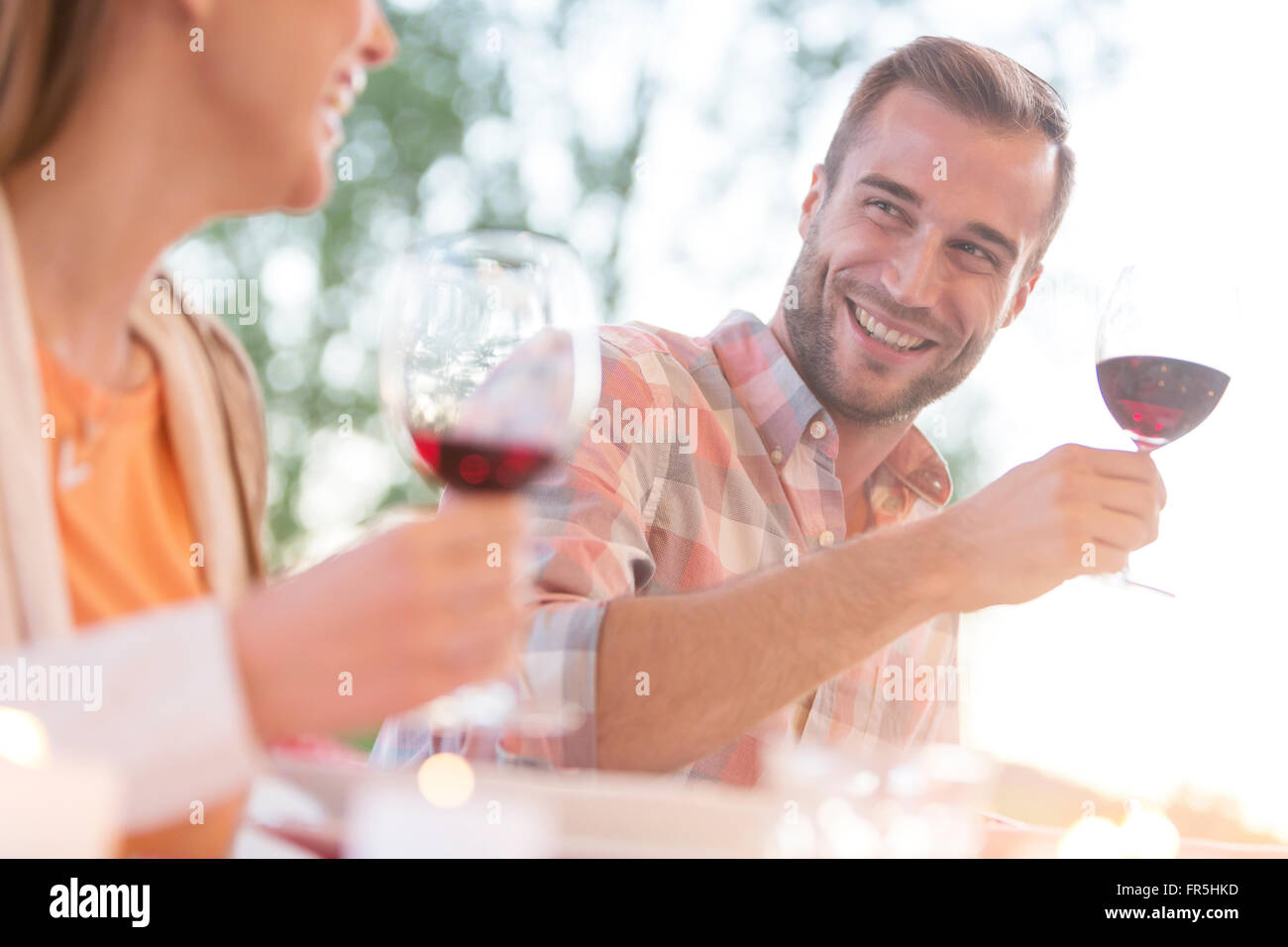 Sorridente coppia giovane di bere vino rosso all'aperto Foto Stock