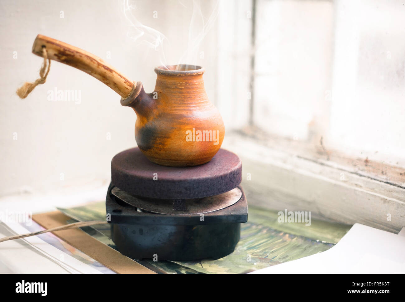 Cezve di caffè su un piccolo fornello sul davanzale vicino alla vecchia finestra Foto Stock