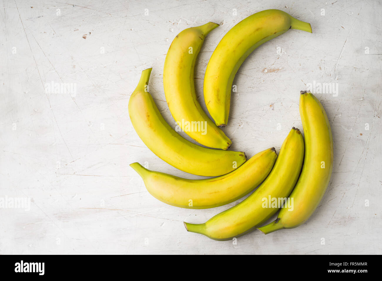 Banane gialle sono previste da una ventola su un bianco tavolo orizzontale Foto Stock
