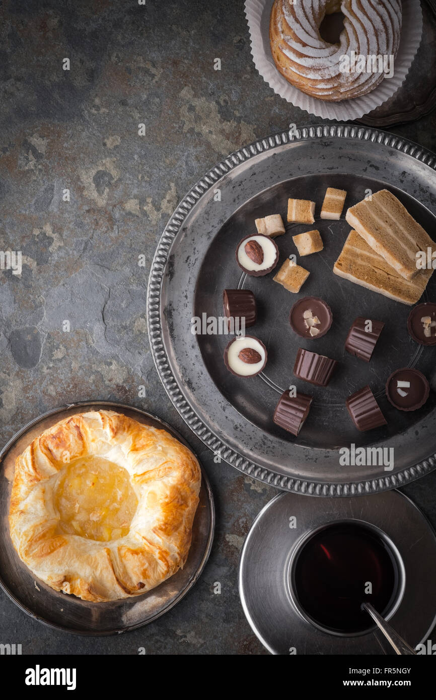 Candy, torte e caffè su una pietra grigia verticale Foto Stock