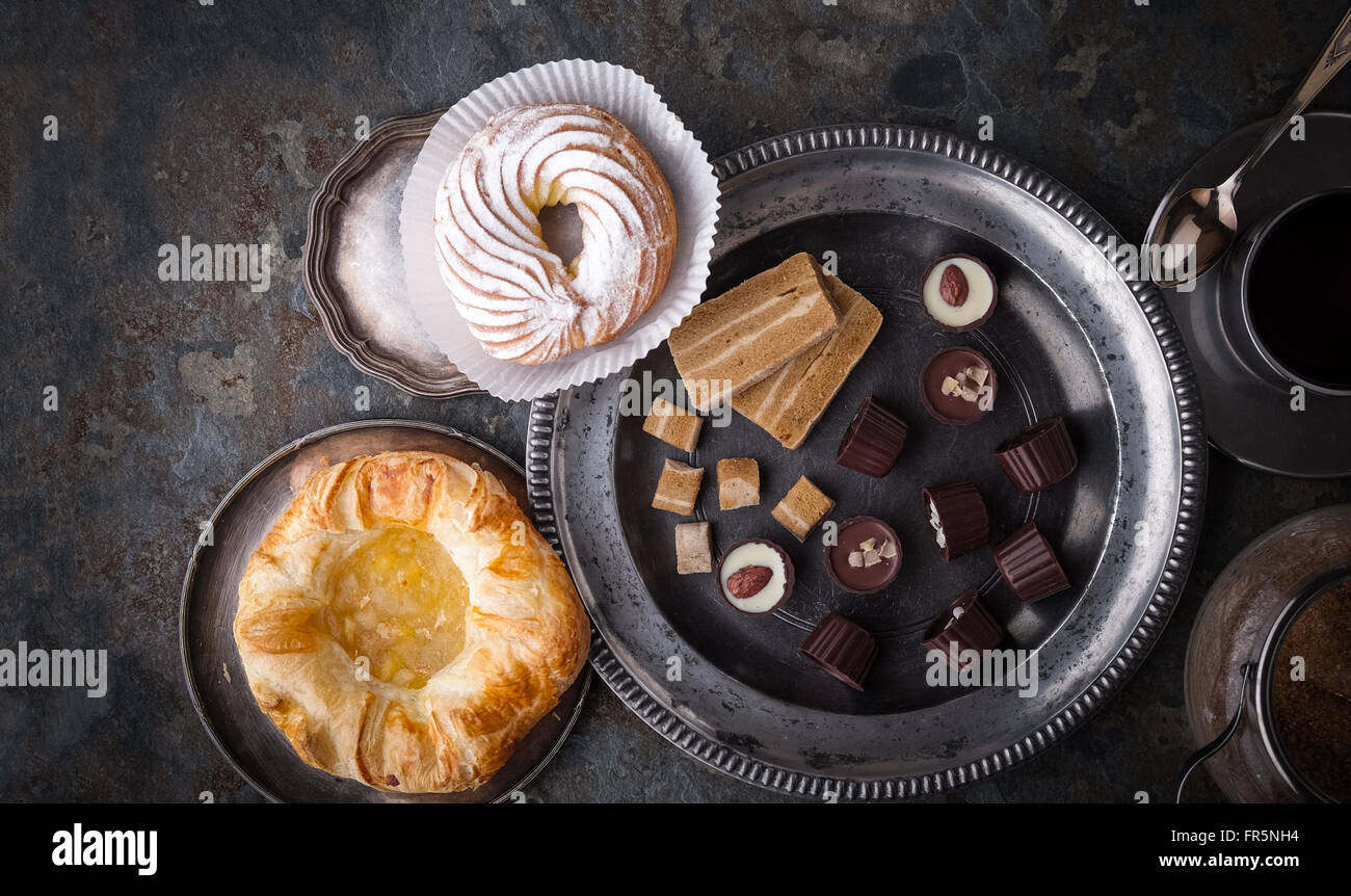 Candy, torte e caffè su una pietra grigia orizzontale Foto Stock