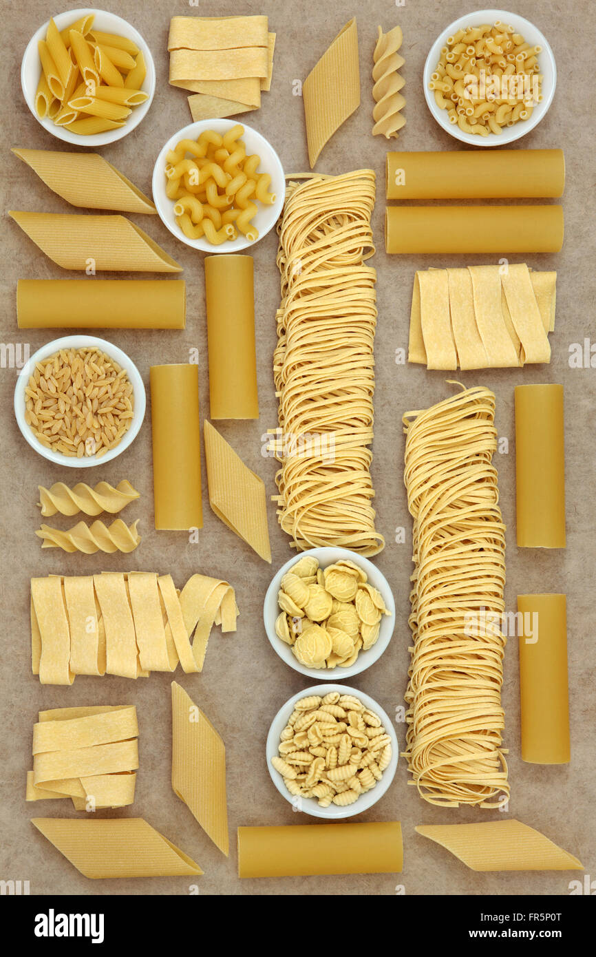 La pasta italiana La cucina del campionatore formando un abstract sfondo su canapa naturale sfondo della carta. Foto Stock