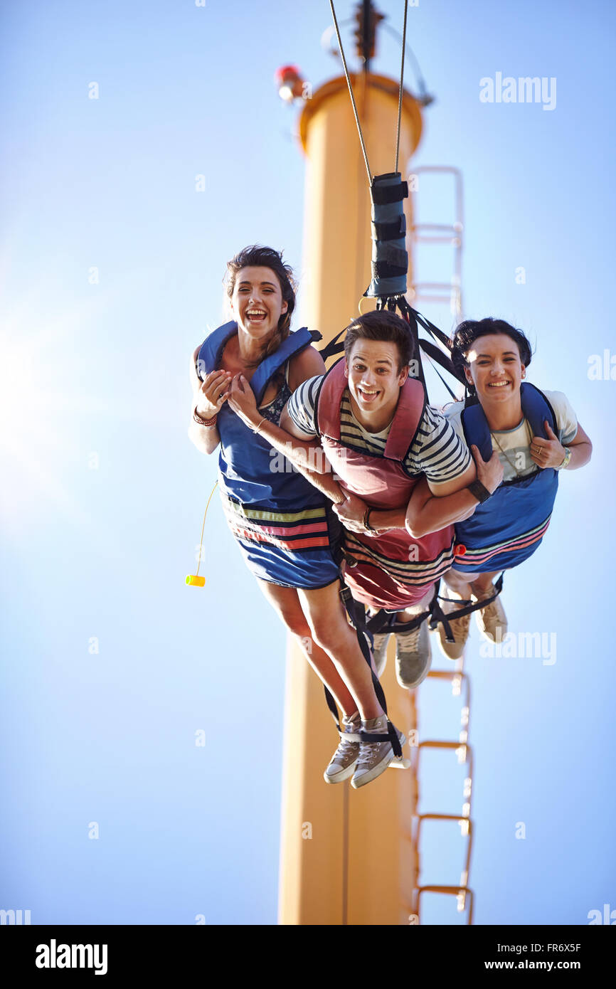 Ritratto sorridente amici bungee jumping presso il parco di divertimenti Foto Stock