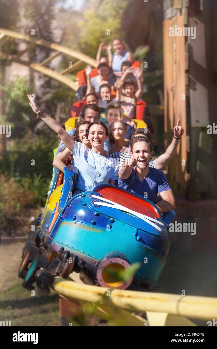 Ritratto di amici entusiastica acclamare e equitazione roller coaster presso il parco di divertimenti Foto Stock