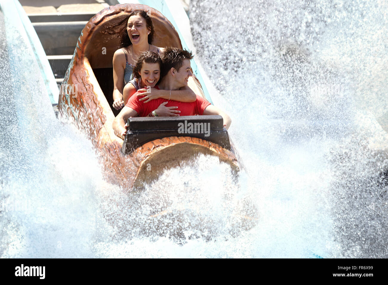 Amici entusiasti getting schizzato in acqua log parco divertimenti ride Foto Stock