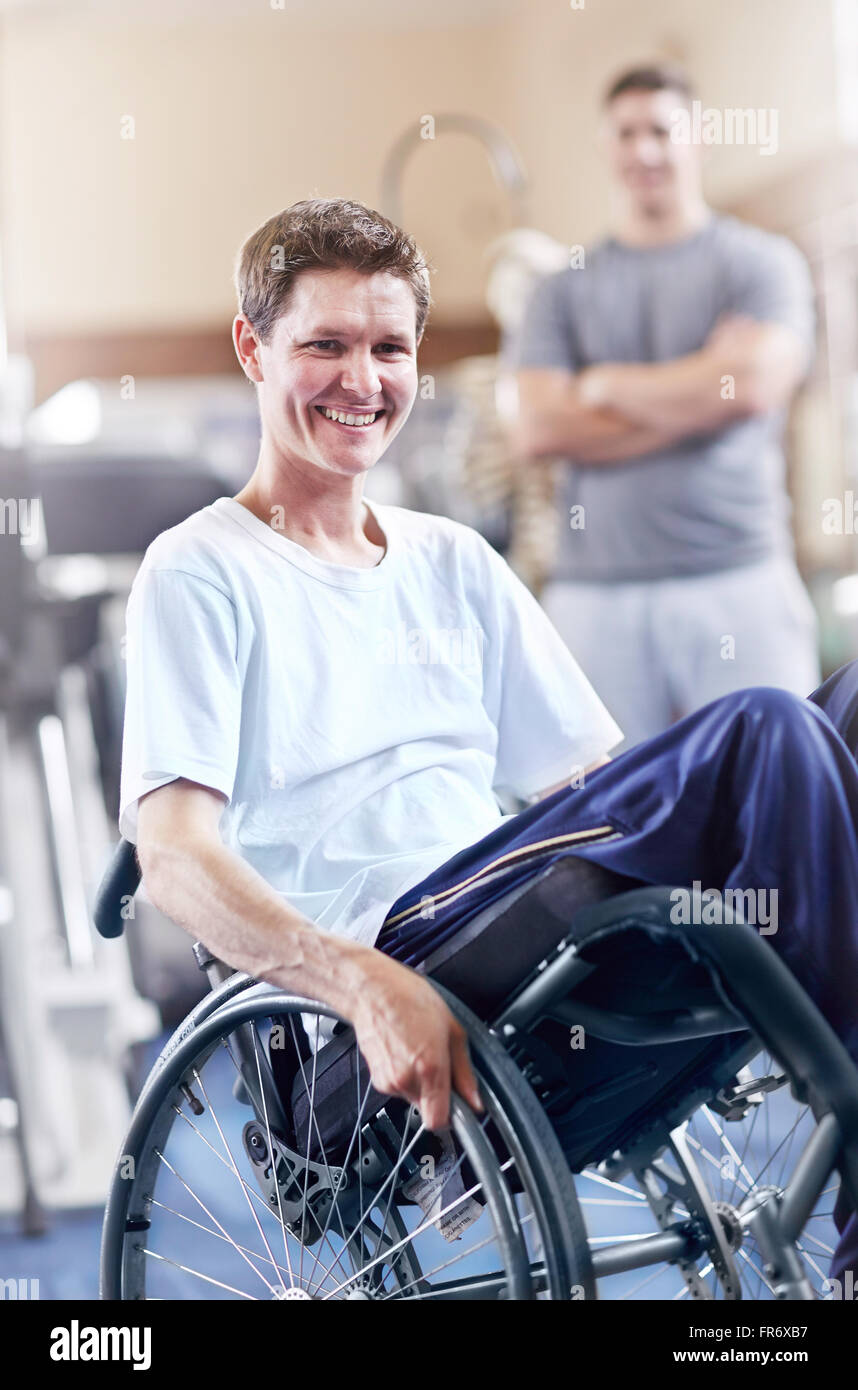 Ritratto uomo sorridente in carrozzella a terapia fisica office Foto Stock