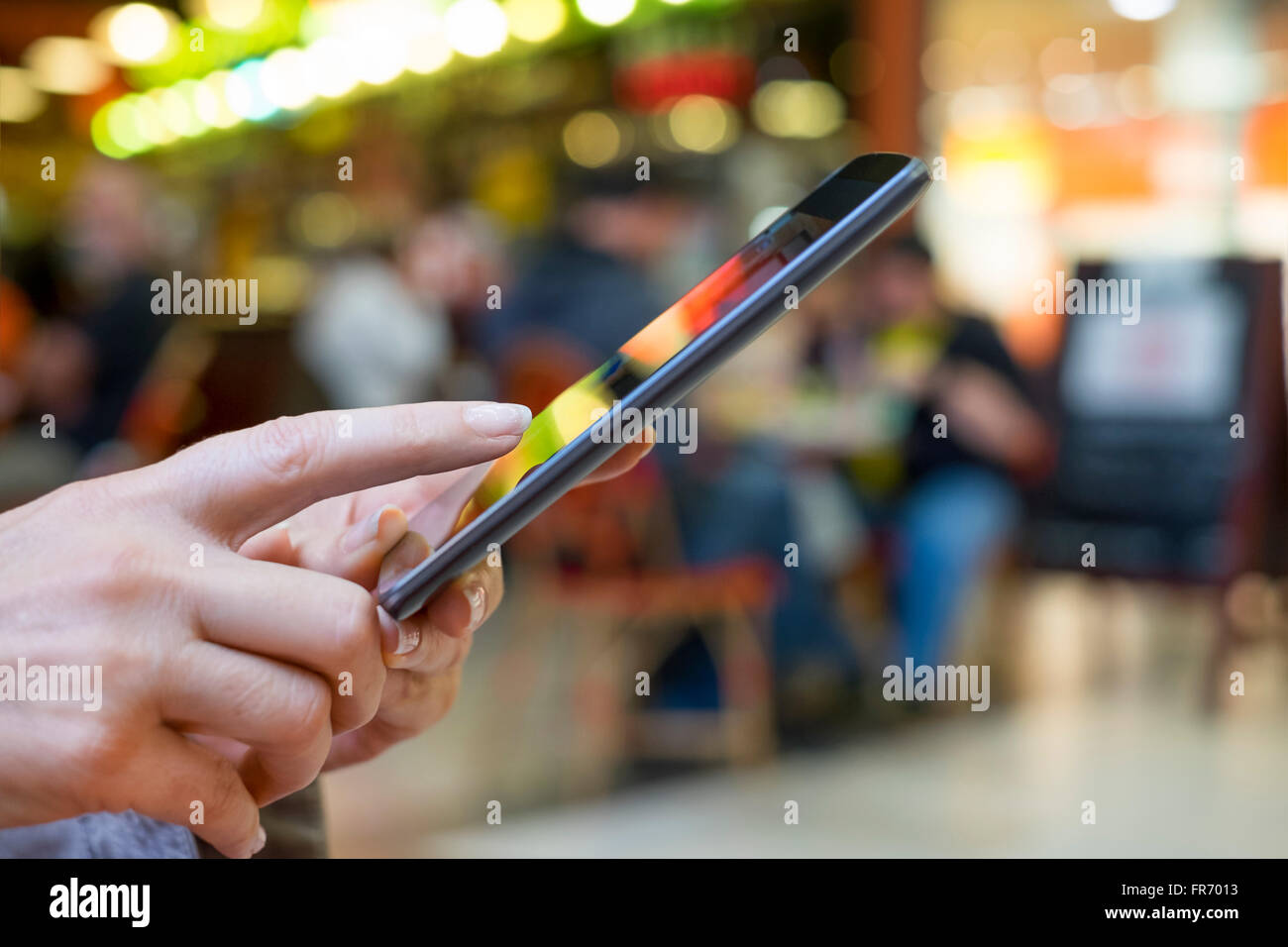 Donna che utilizza il cellulare in Mall. App, i messaggi di testo, sms, messaggio, Mail Foto Stock