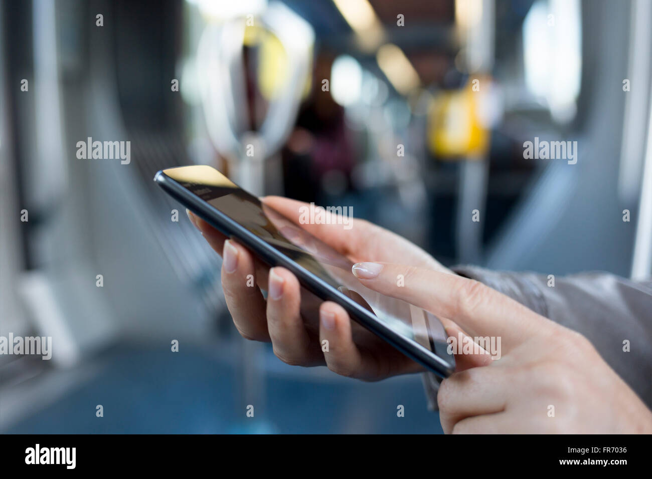 Femmina con il suo smart-phone in metropolitana. Metro. Sms, messaggio, app Foto Stock