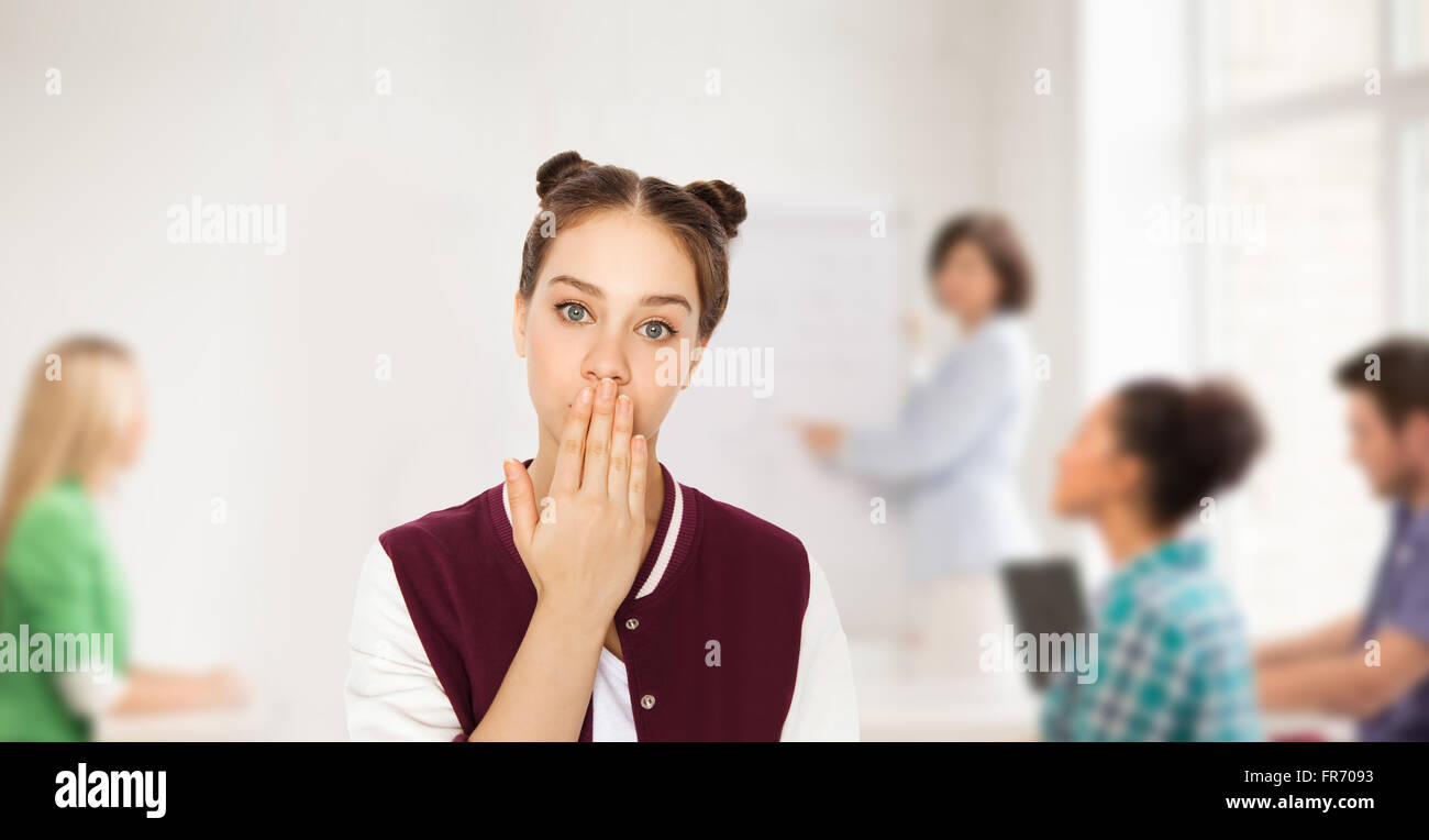 Confuso studente ragazza che copre la bocca con la mano Foto Stock