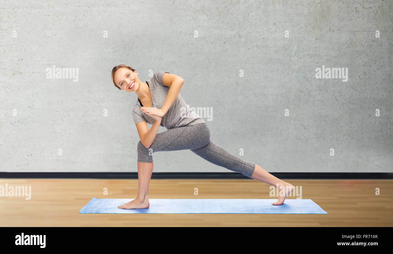 Donna fare yoga basso angolo lunge pone sul tappeto Foto Stock