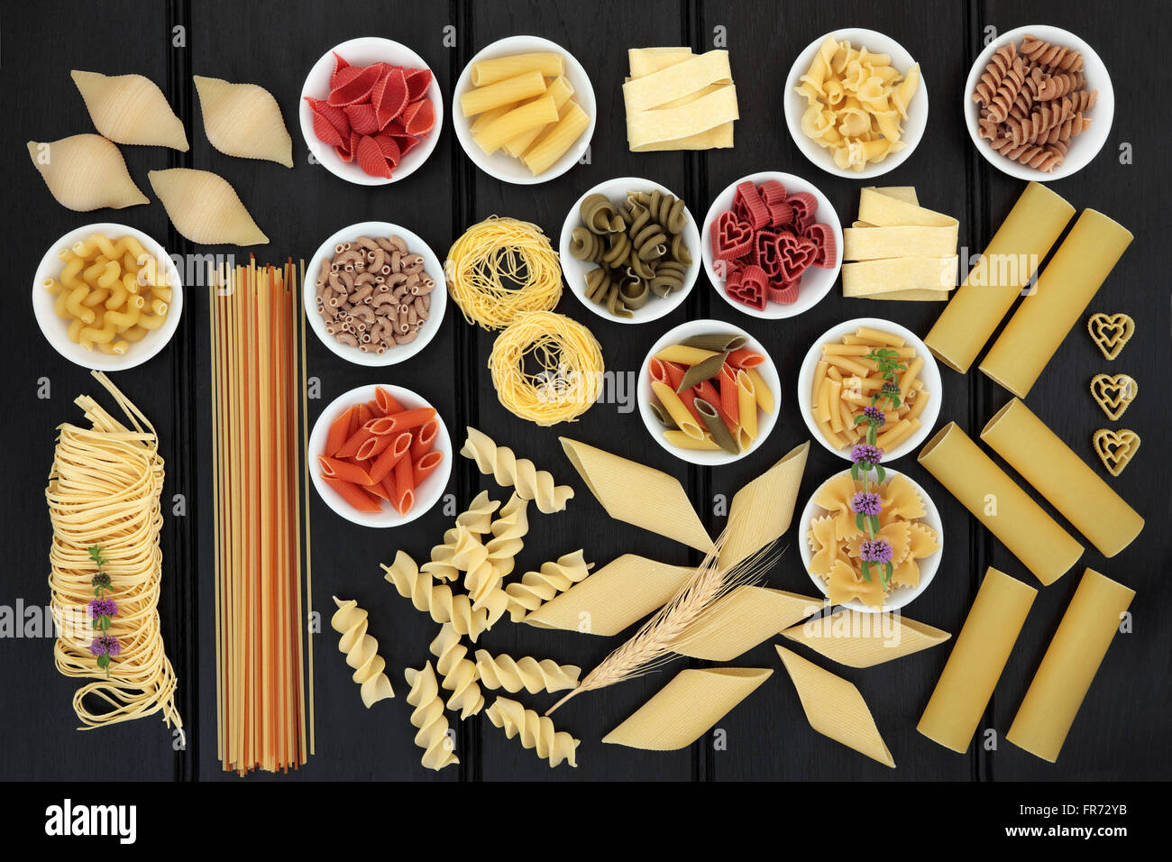 Grandi secchi tutto pasta di grano selezione con pomodoro, spinaci e barbabietole varietà colorate su legno scuro dello sfondo. Foto Stock