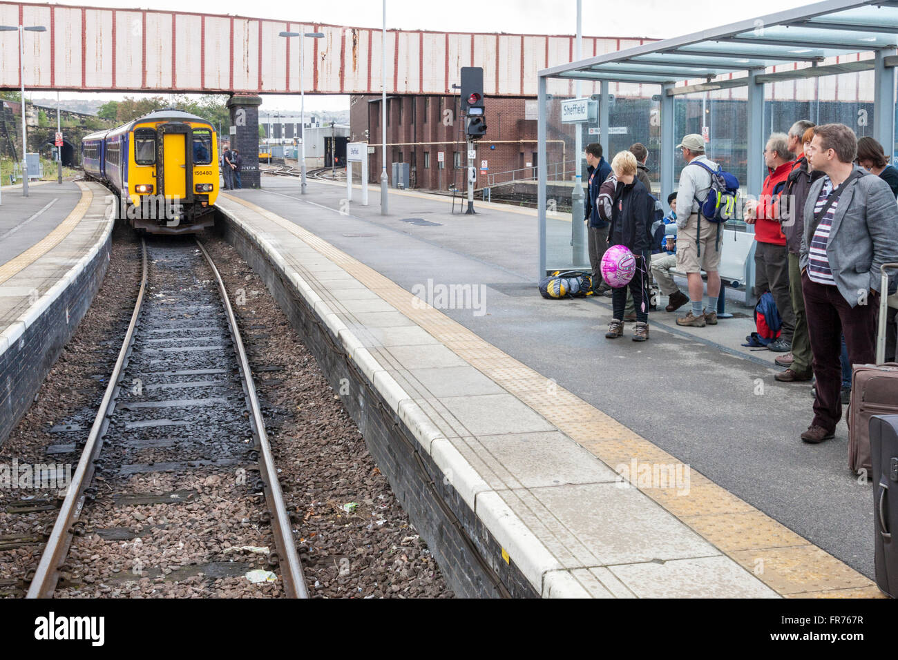 In treno arrivando a una piattaforma della baia a Sheffield stazione ferroviaria, nello Yorkshire, Inghilterra, Regno Unito Foto Stock