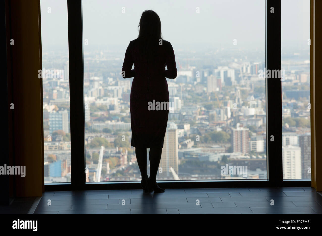 Una donna si affaccia sulla città di Londra Foto Stock