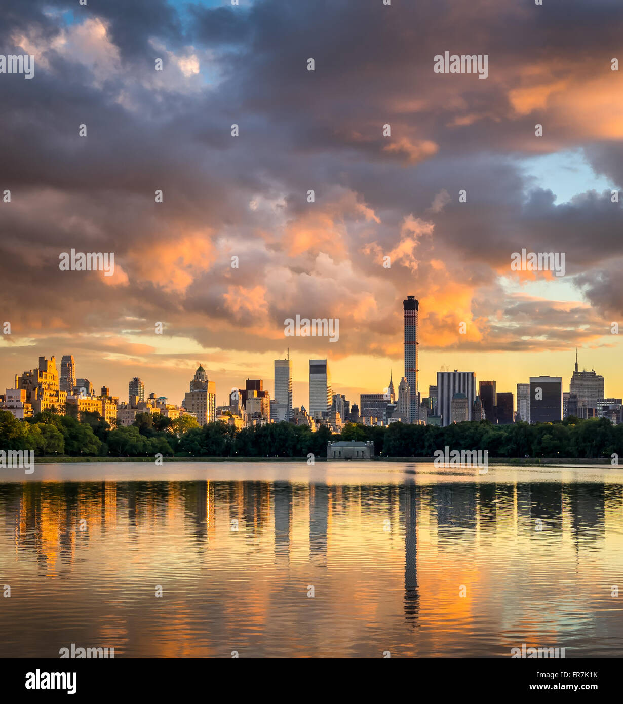 Fiery vista al tramonto di fronte al Central Park di Jacqueline Kennedy Onassis serbatoio verso il Midtown Manhattan skyline di New York City Foto Stock