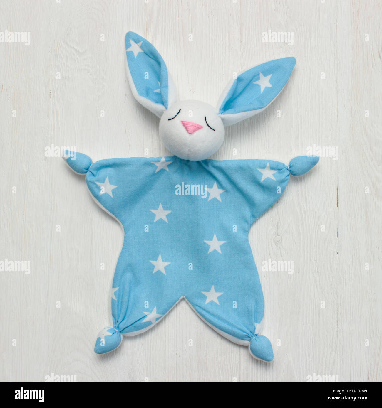 Bianco e blu toy bunny sulla luce sullo sfondo di legno Foto Stock