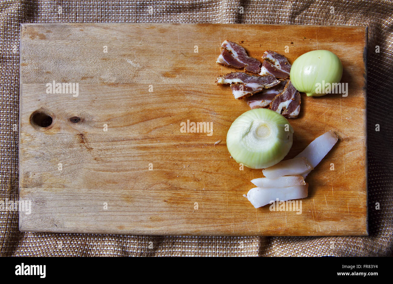 Il sale di carne e gli ingredienti per cucinare intorno al bordo di taglio su sfondo rustico, vista dall'alto, il luogo per il testo Foto Stock