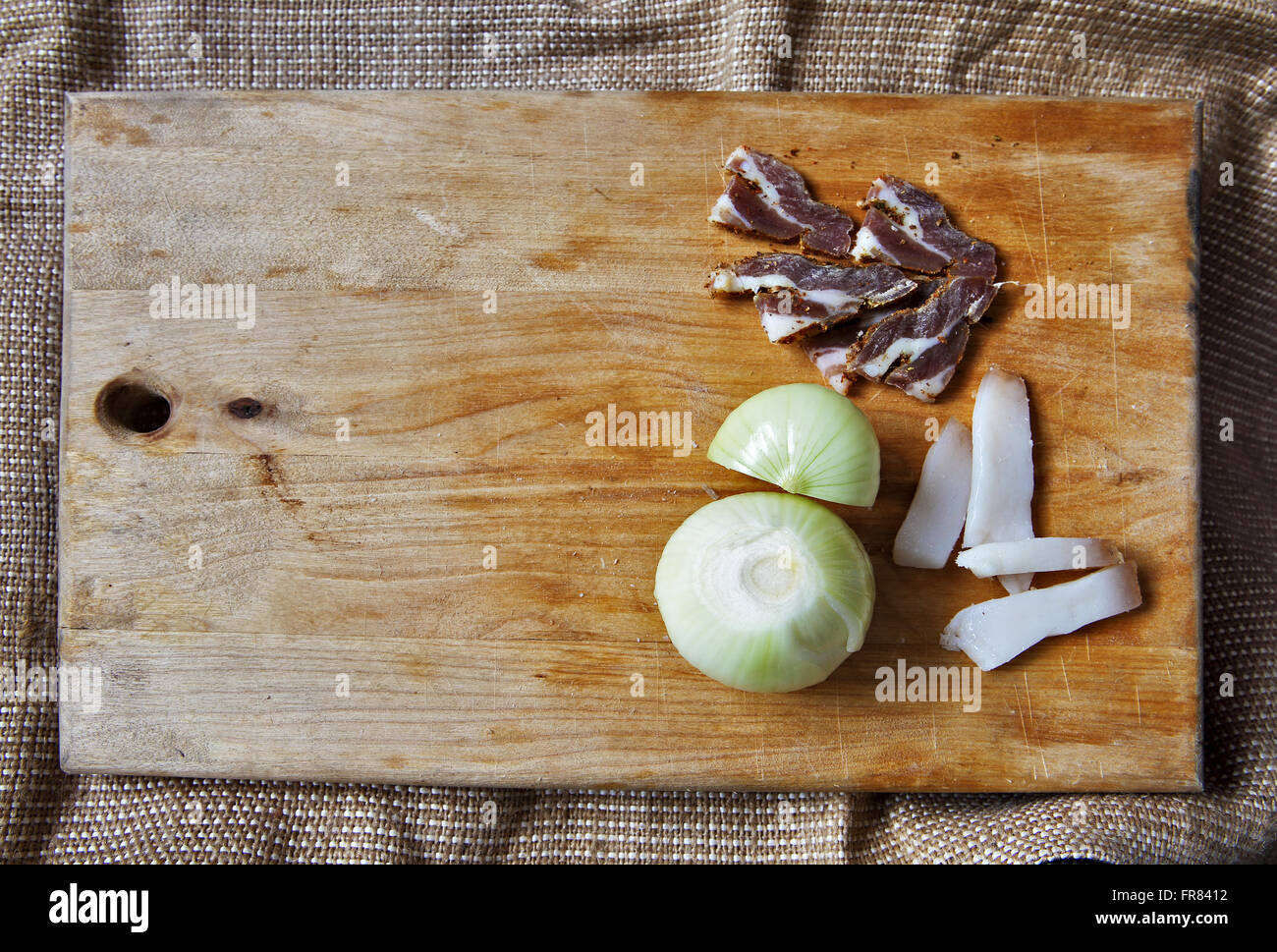 Il sale di carne e gli ingredienti per cucinare intorno al bordo di taglio su sfondo rustico, vista dall'alto, il luogo per il testo Foto Stock