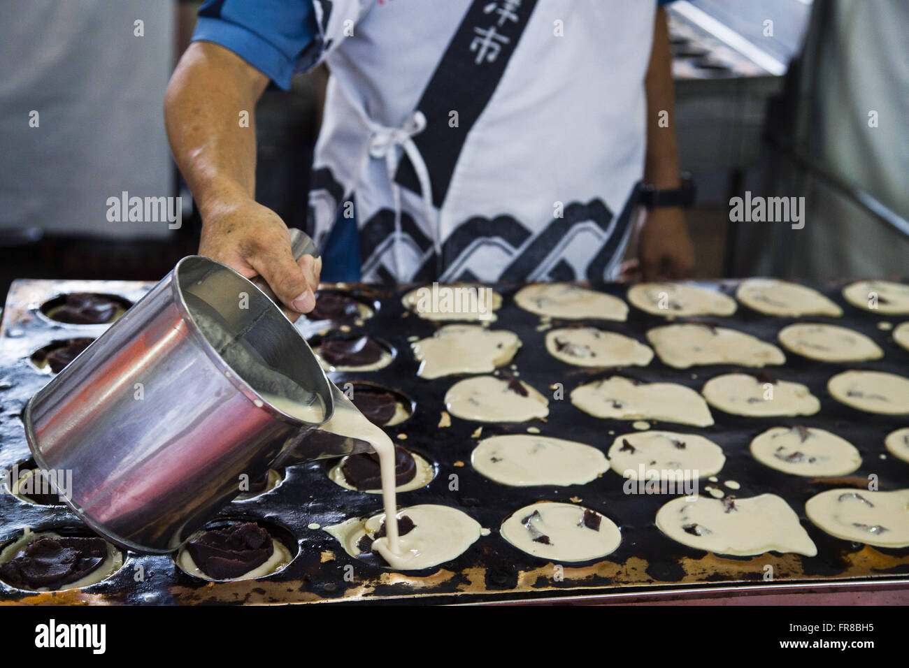 L'uomo la preparazione di dolci fagioli azuki chiamato imagawayaki Foto Stock