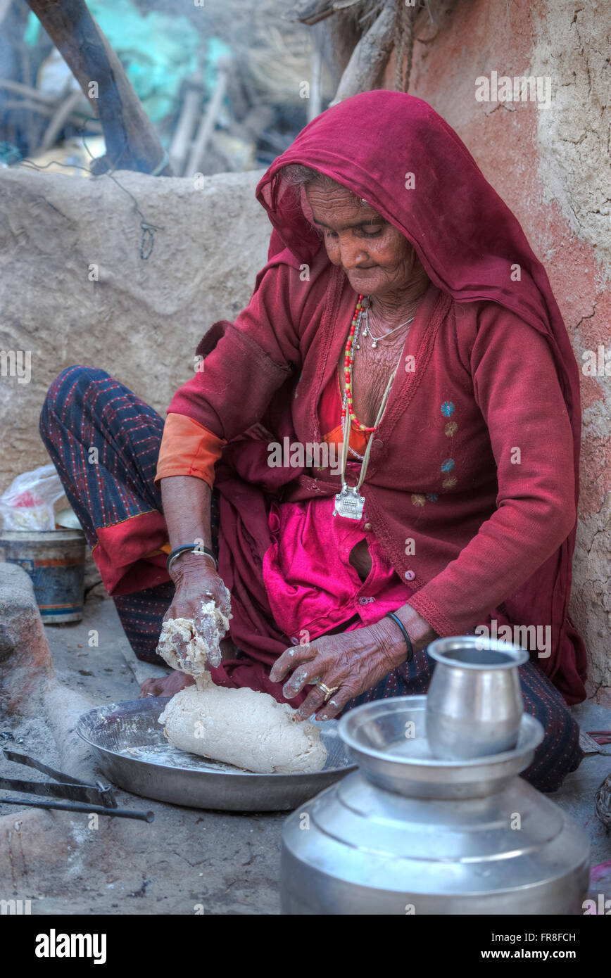 La donna in un villaggio tribale vicino a Jodhpur è la cottura ciabatti nella sua cucina esterna Foto Stock