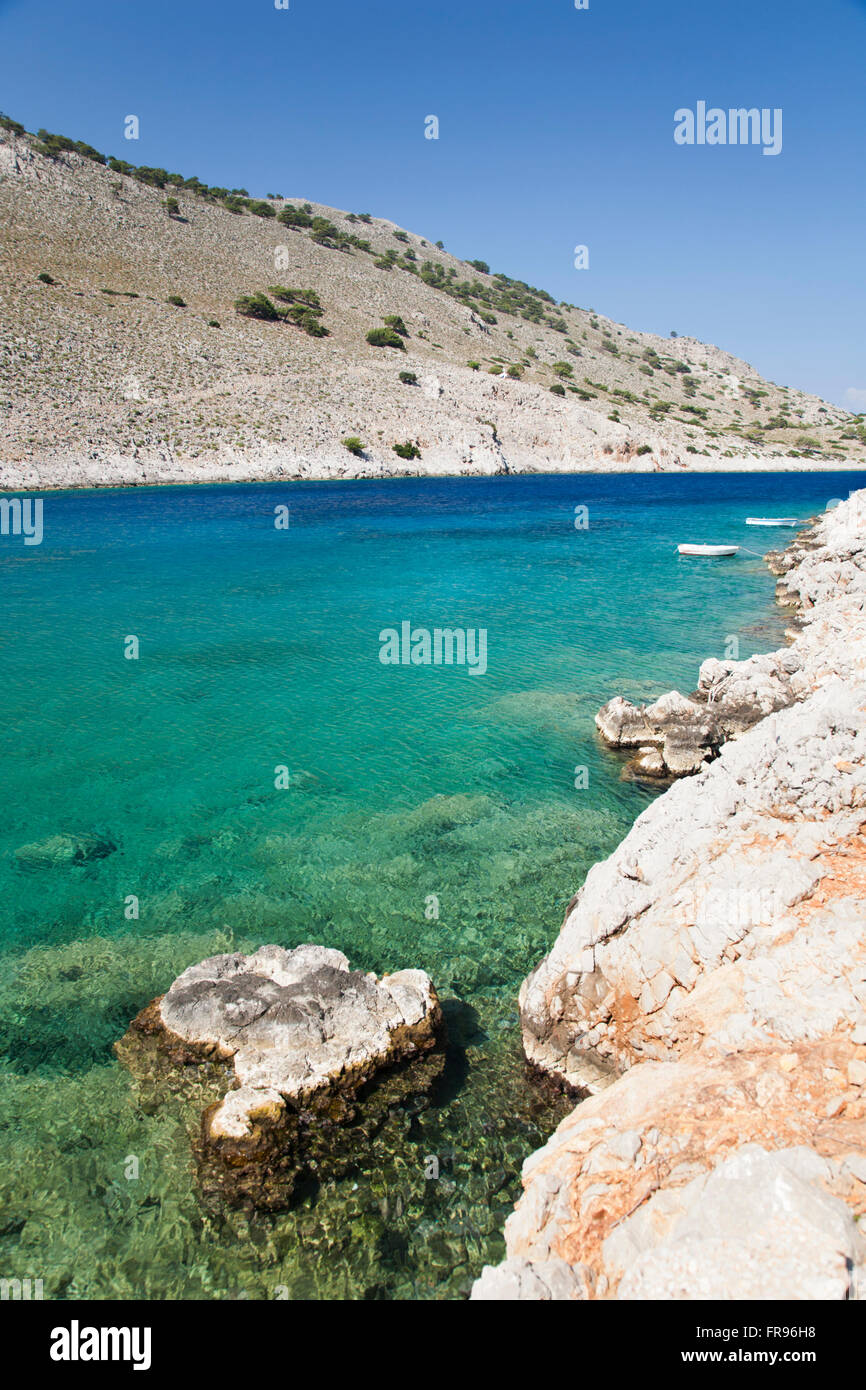 Marathounda, Symi, Egeo Meridionale, Grecia. Vista attraverso le acque turchesi della baia Marathounda. Foto Stock