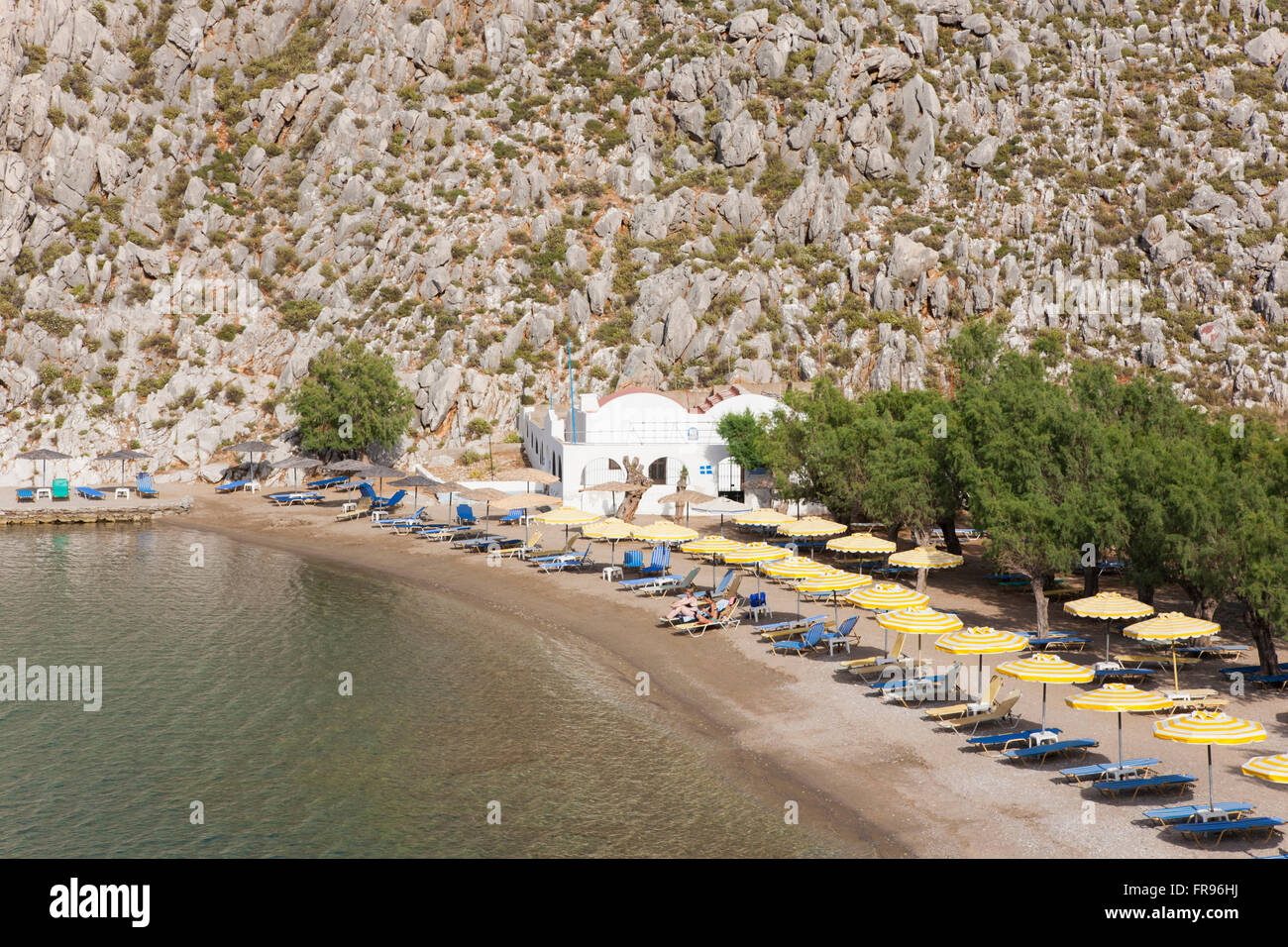 Pazienti pediatrici, Symi, Egeo Meridionale, Grecia. Vista sulla spiaggia appartata di Agios Nikolaos. Foto Stock