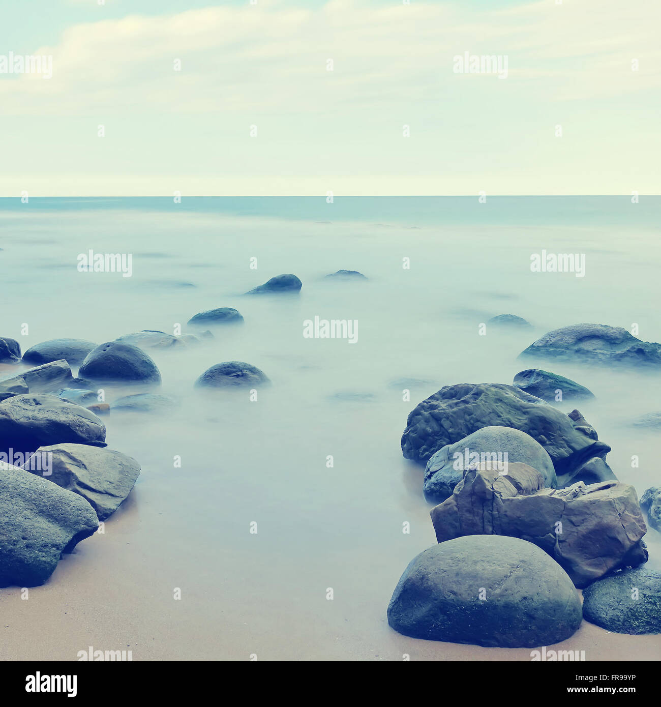 Mare calmo lunga esposizione shot.pietre nella nebbia misteriosa delle onde del mare.La foto in stile vintage Foto Stock