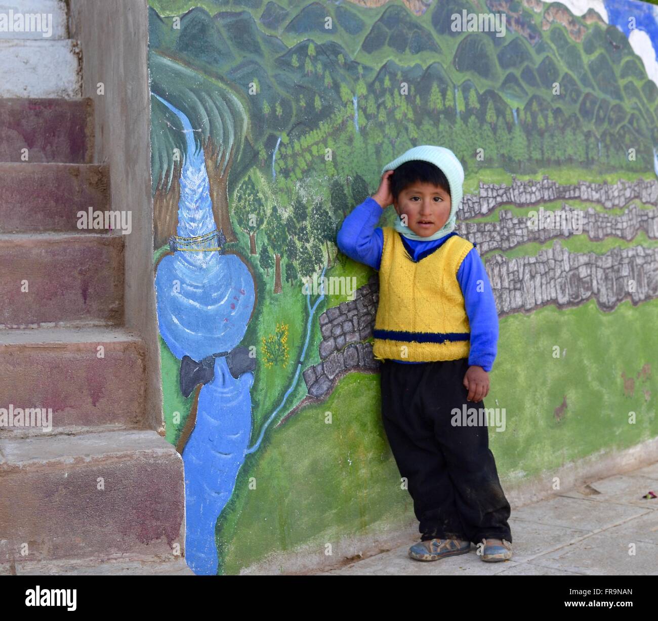 Ragazzo peruviano in piedi da murale di Cusco Foto Stock